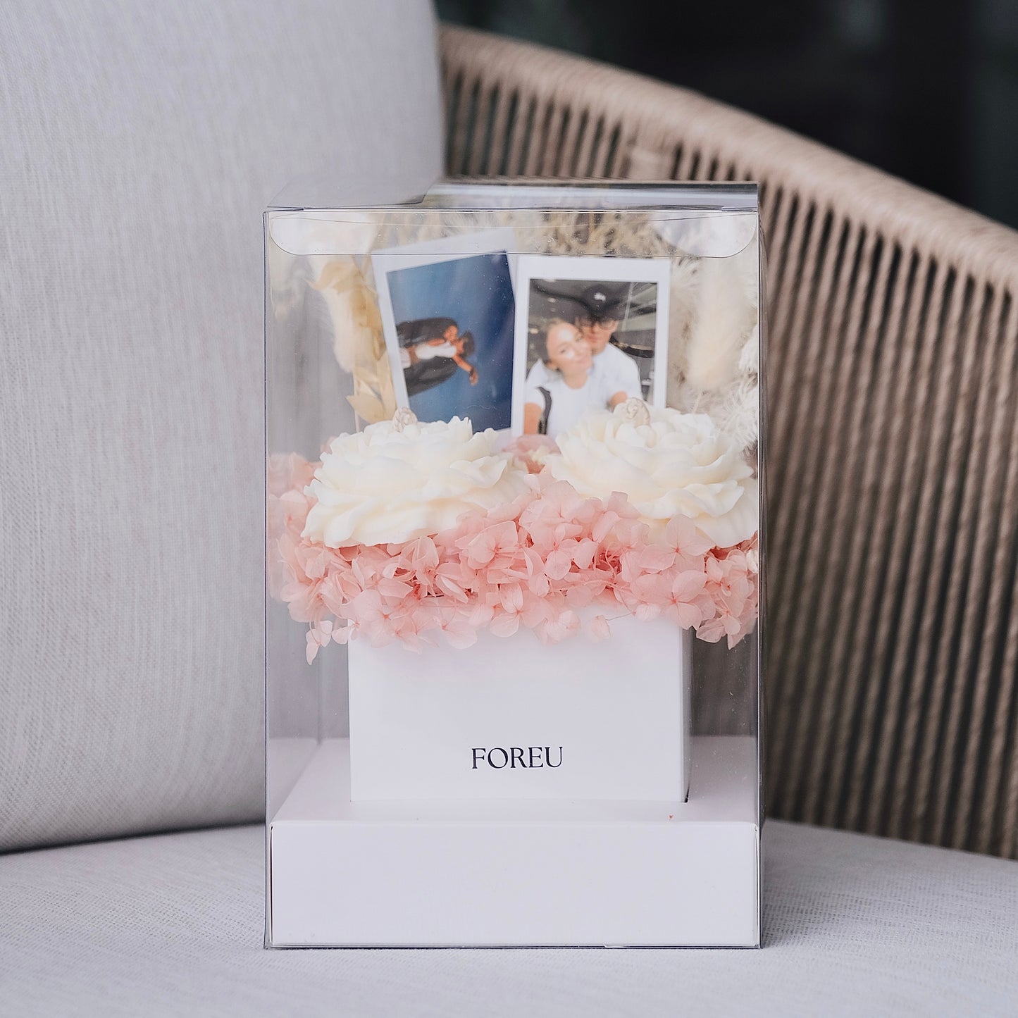 Decorative photo frame with flowers and photos on a surface in a premium flower box arrangement with polaroids