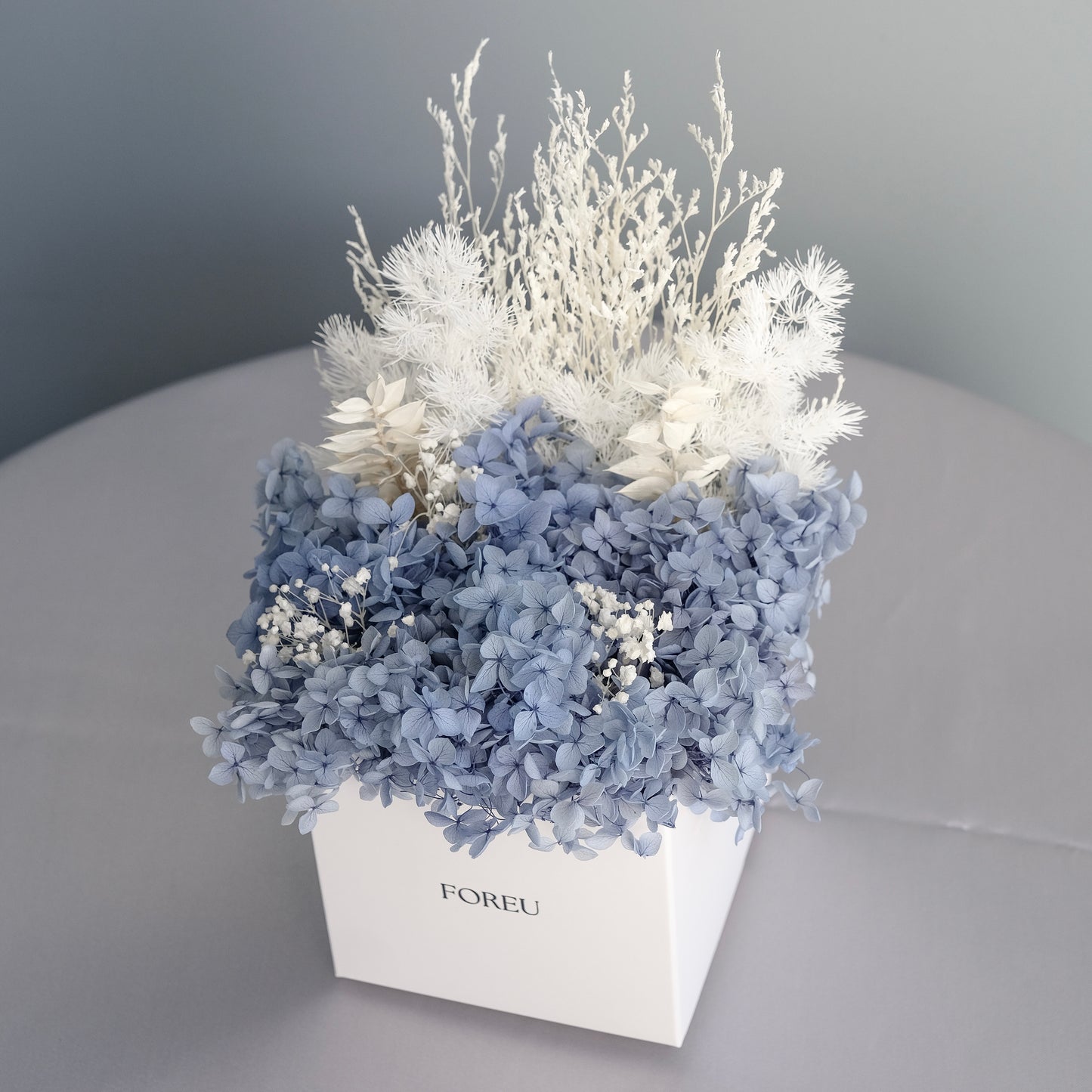 Dried hydrangeas, curated arrangement of preserved flowers in midnight blue colourway for home decoration or gifting.