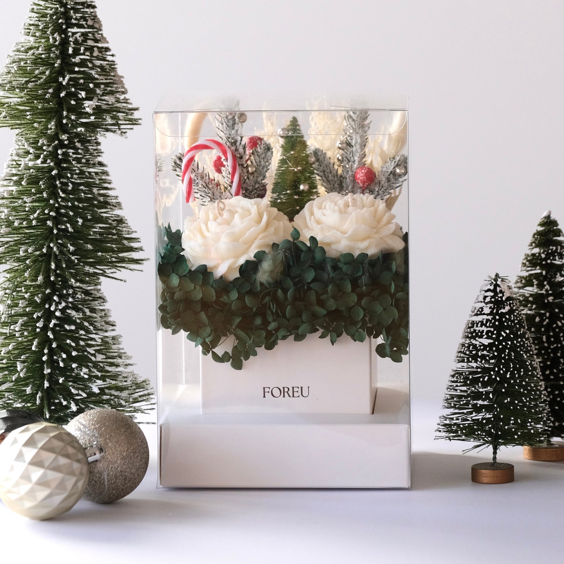 FOREU Studio Limited Edition Christmas Candle Box with soy peony candles, dark green hydrangeas, and festive holiday decorations in a clear premium gift box luxury handcrafted Christmas gift idea. christmas gifting timeless premium box for present with ornaments and christmas display includes soy peony flowers and dark green preserved hydrangeas 