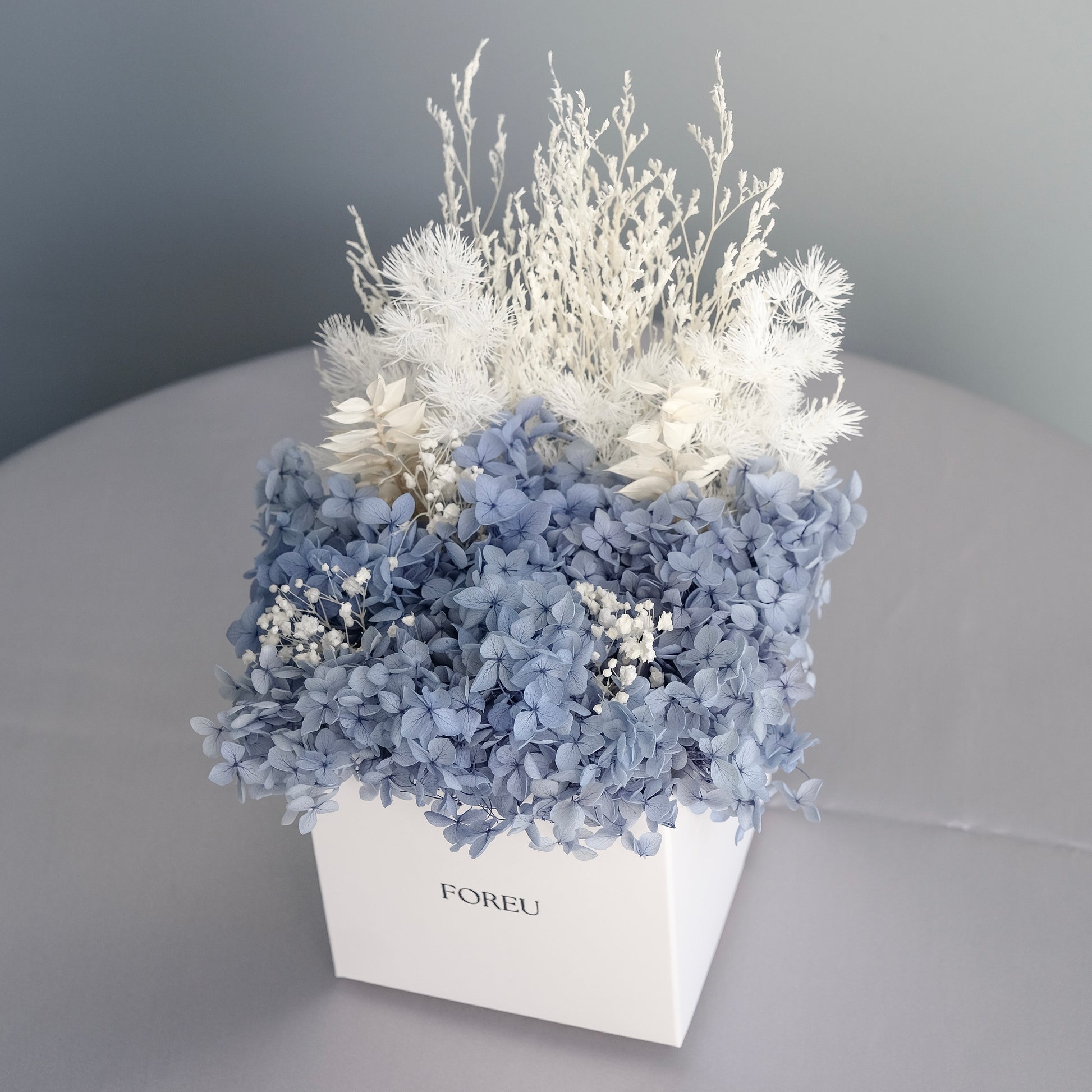 Dried hydrangeas, curated arrangement of preserved flowers in midnight blue colourway for home decoration or gifting.